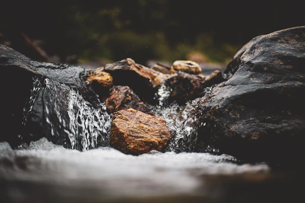 Close-up of fresh water flowing over smooth stones in a natural creek.