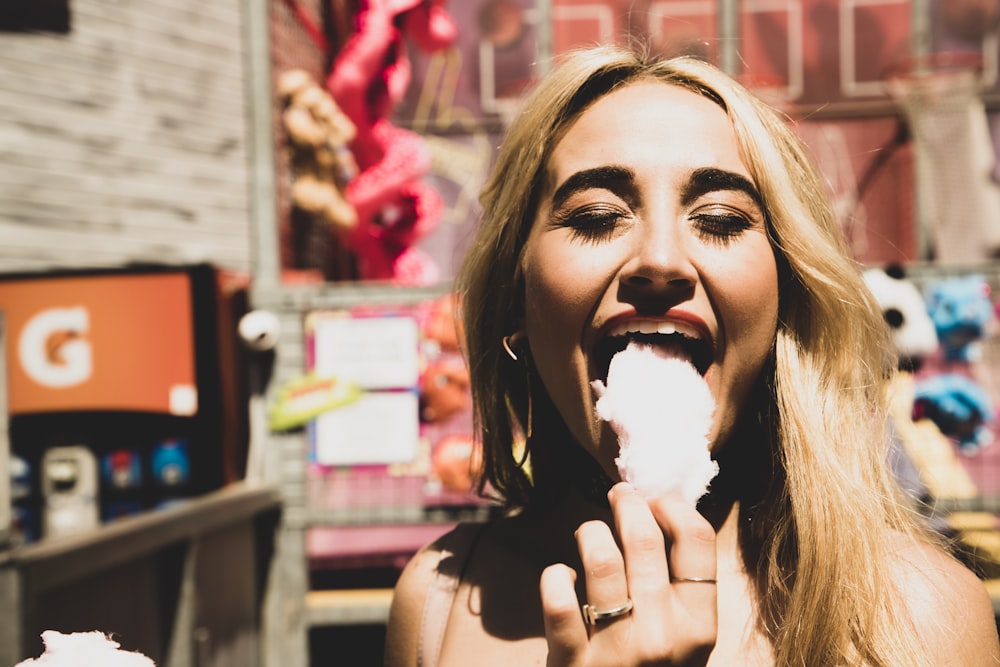 woman eating food near brown store