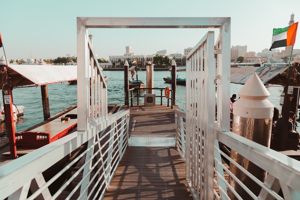 a wooden bridge with a white railing and a flag on top of it