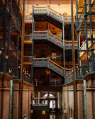Historic wrought iron staircase inside the château with warm lighting.