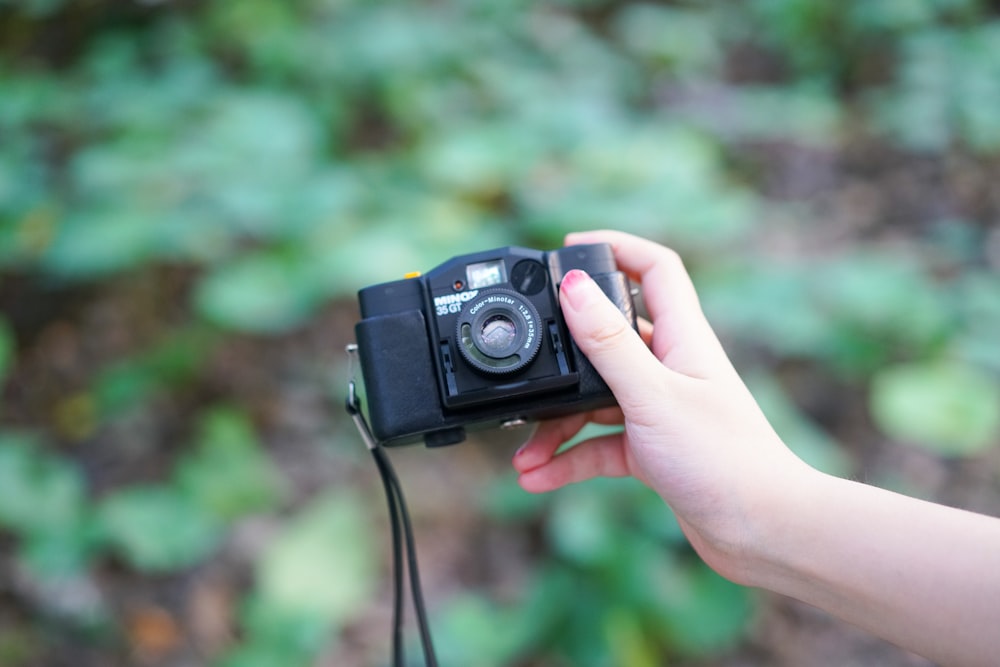 person using black DSLR camera