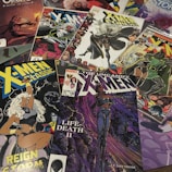 A collection of X-Men comic books spread out, featuring various covers and illustrations. Prominent characters like Storm are visible in dynamic poses with vibrant colors. The covers include titles like 'X-Men Classic' and 'The Uncanny X-Men' with distinct artwork styles and comic book logos.