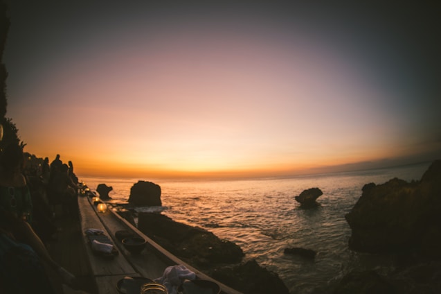 A warm family moment on a wooden porch overlooking a calm ocean at sunset, symbolizing peace and belonging.