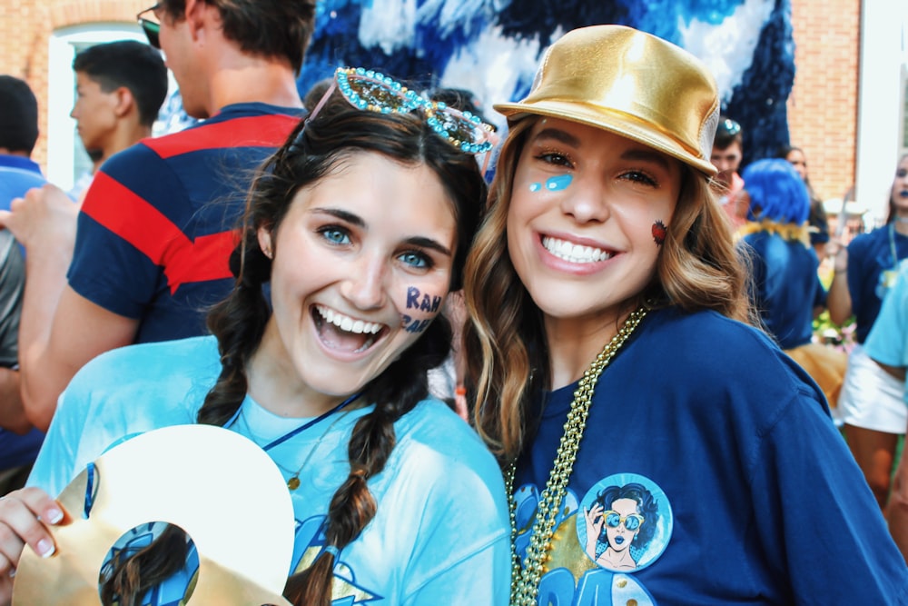 two smiling woman wearing blue shirts