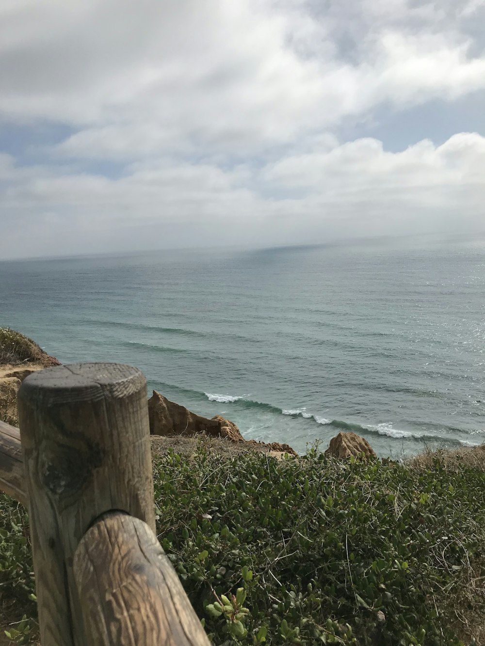 cliff beside body of water under blue sky during daytime