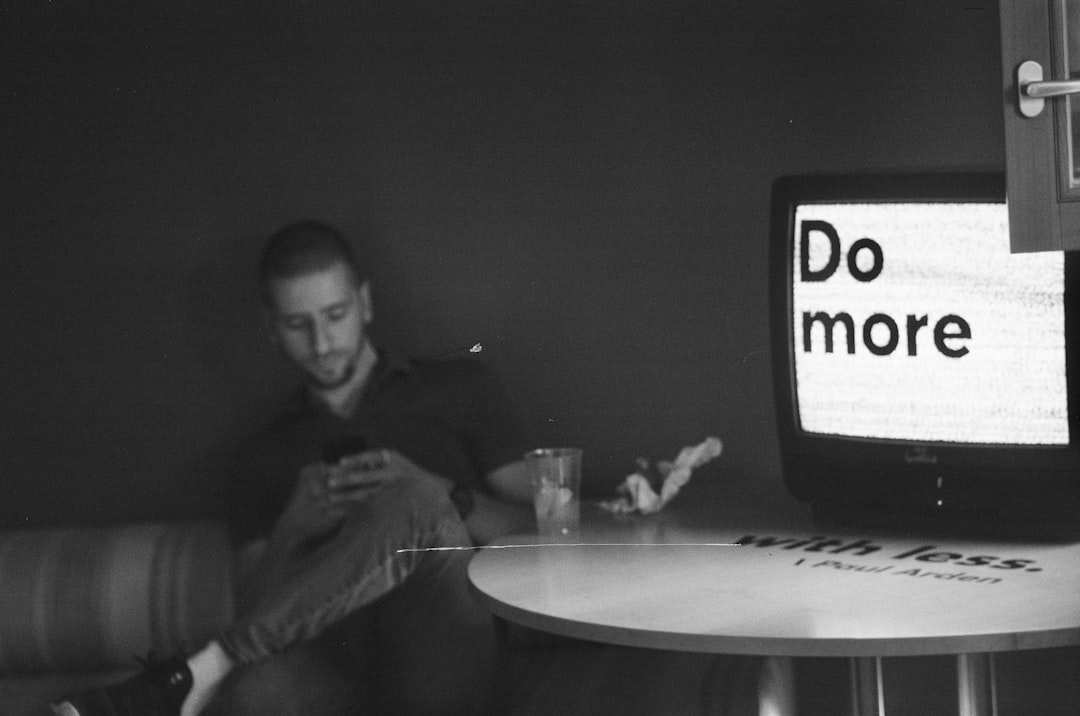 gray-scale photo of man sitting on chair