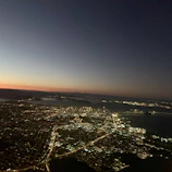 Cinematic aerial view of a modern cityscape under twilight with deep black and purple hues.