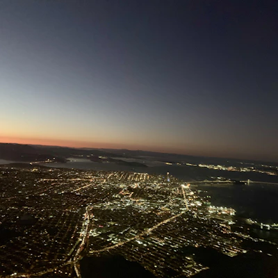 Cinematic aerial view of a modern cityscape under twilight with deep black and purple hues.