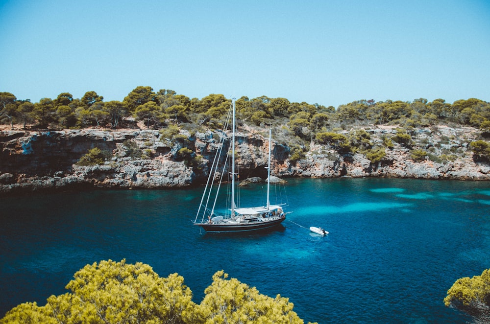 brown and white sailboat at middle of sea