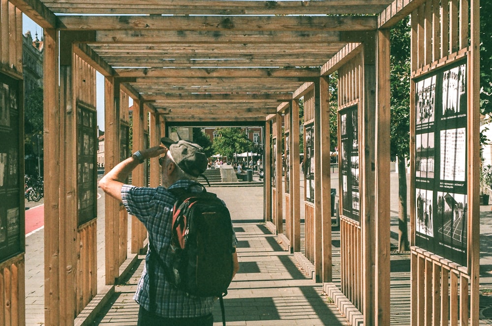 man standing on brown wooden frame during daytime