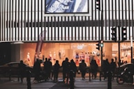 A group of friends wearing Lumina Apparel pieces, laughing and crossing a sunlit intersection.