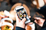 Close-up of a food photographer capturing a vibrant dish in natural light.