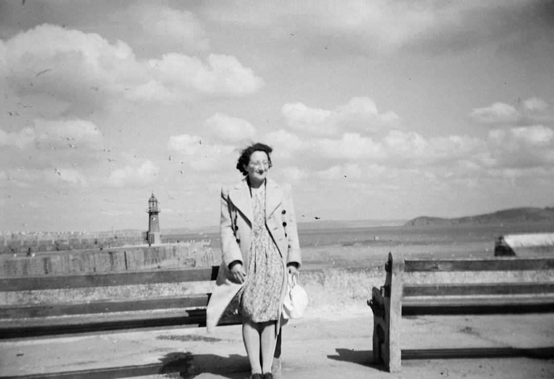 woman wearing coat standing beside bench