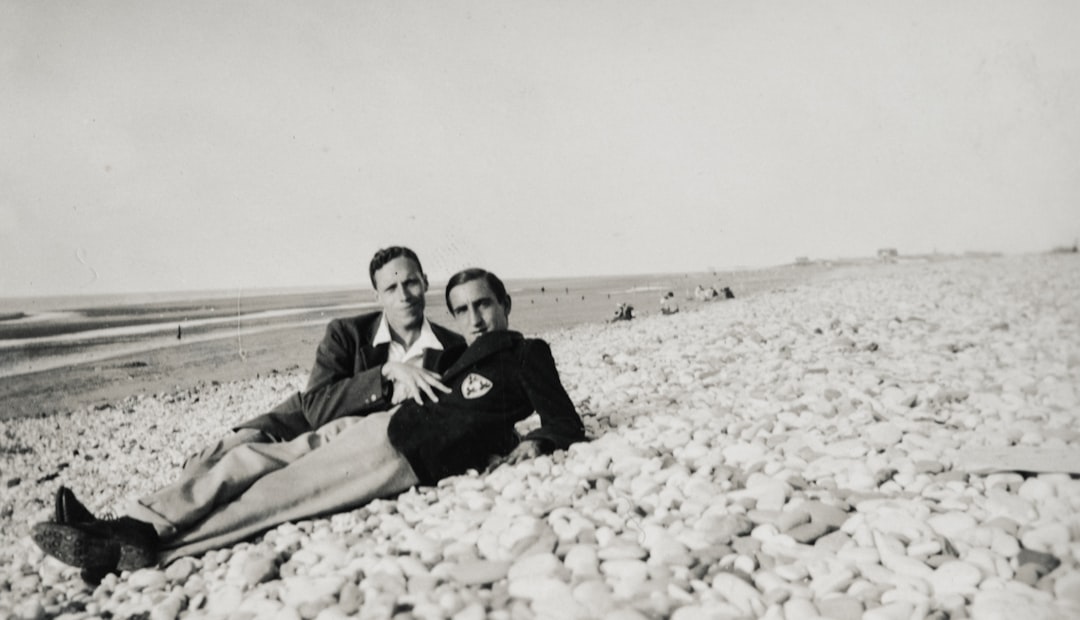 two men lying on seashore