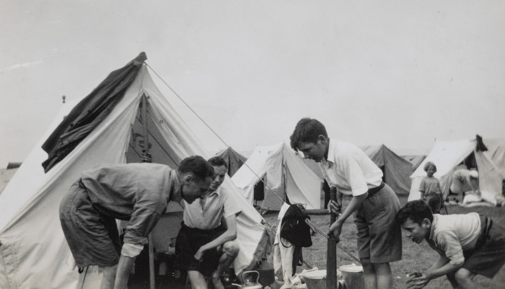 grayscale photo of children near tent