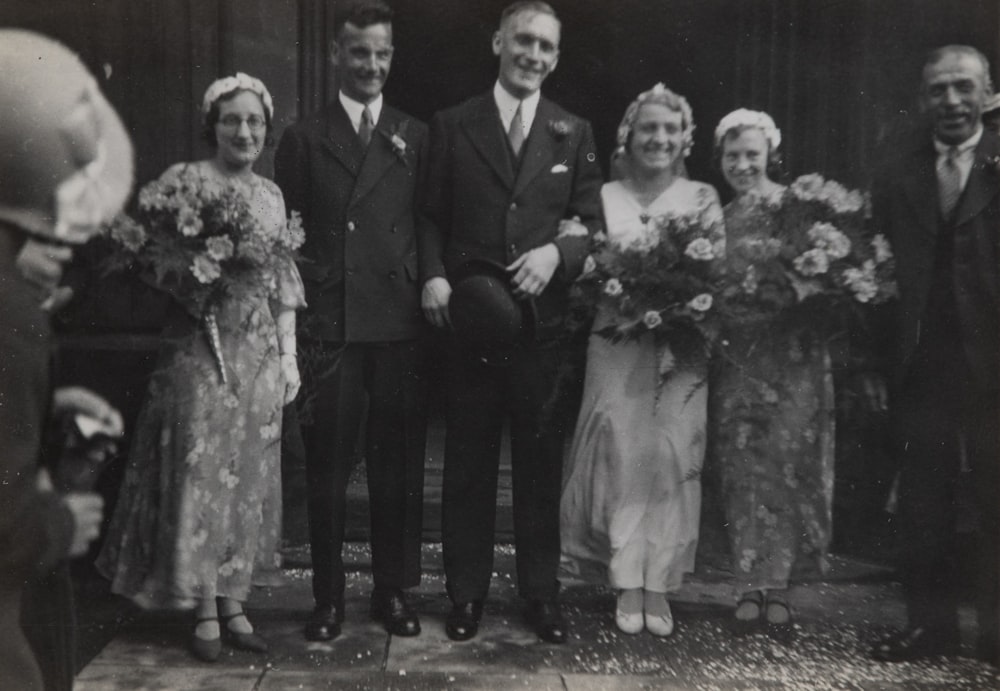 six people wearing suits and dresses