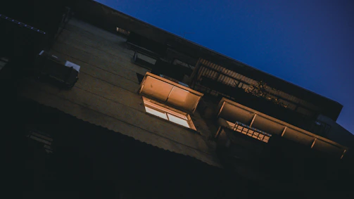 Nighttime shot of apartment balconies with soft glowing lights.