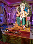 Intricate carving of Lord Ganesha seated with modak sweets in a peaceful temple nook.