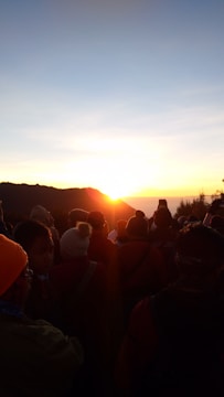 A group of church members praying together outdoors at sunrise.