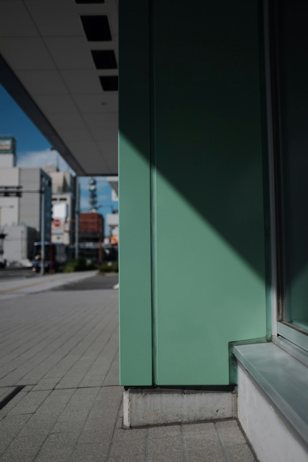 a green building with a bench in front of it