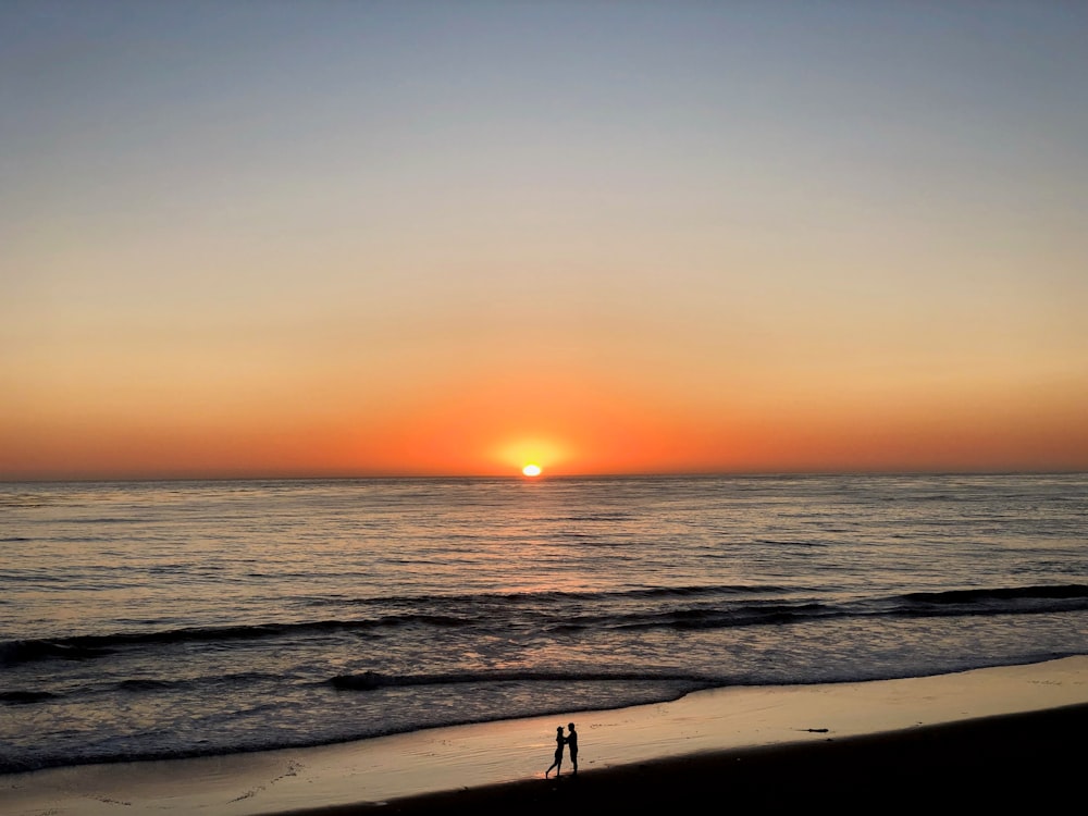 two people standing in seashore