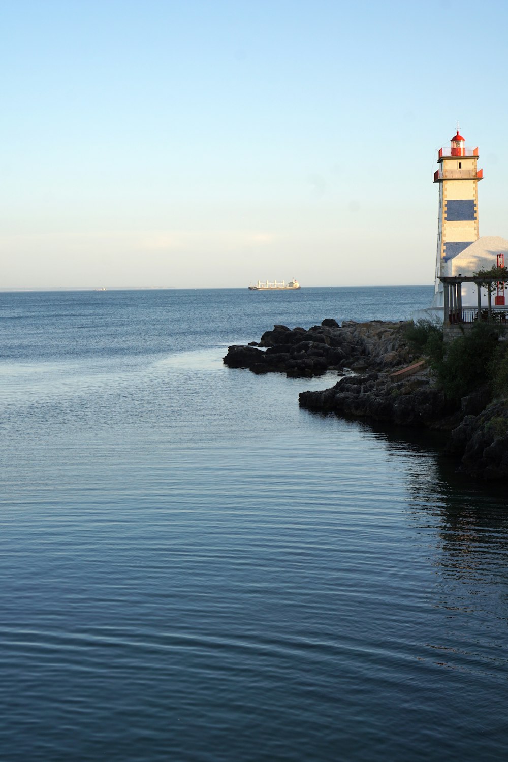 a light house sitting on the edge of a body of water