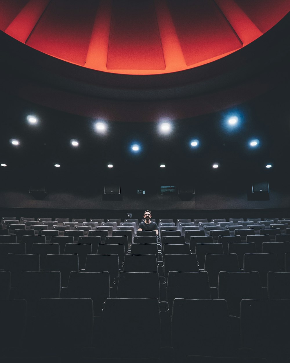 eine Person, die in einem Theater auf einem Stuhl sitzt