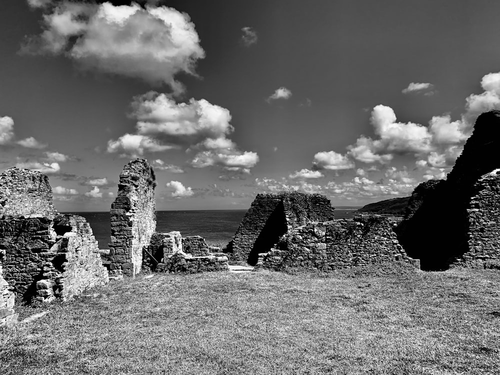 a black and white photo of ruins on a hill