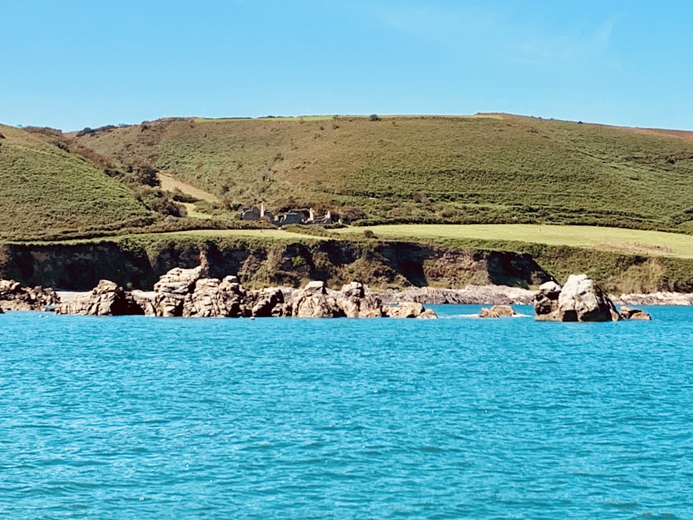 a body of water with a hill in the background