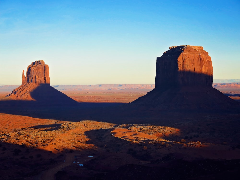 a view of a desert with a mountain in the background