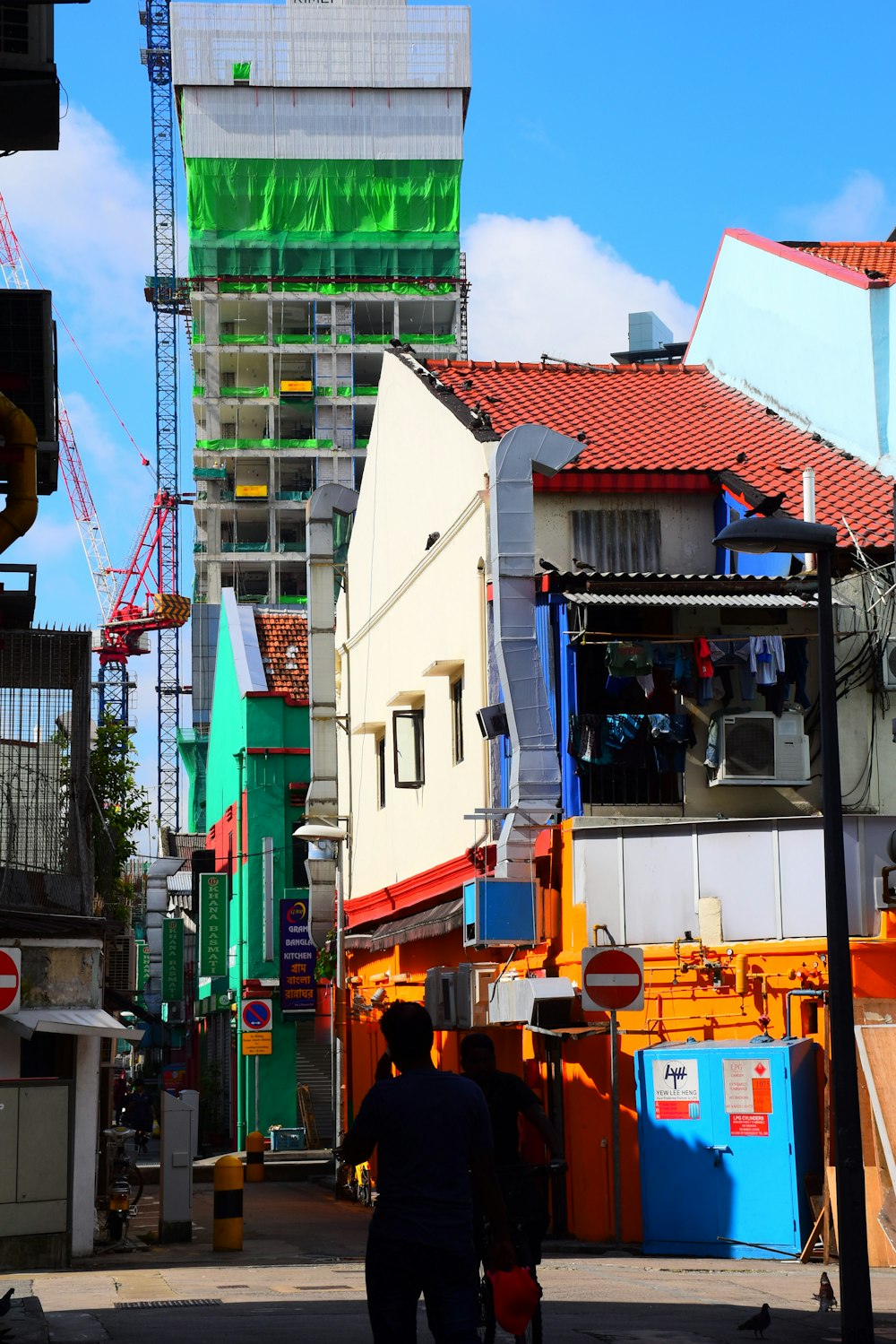 a man walking down a street next to tall buildings