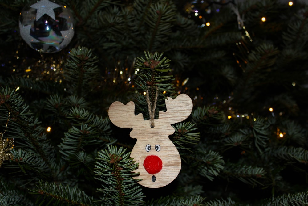 a wooden reindeer ornament hanging from a christmas tree