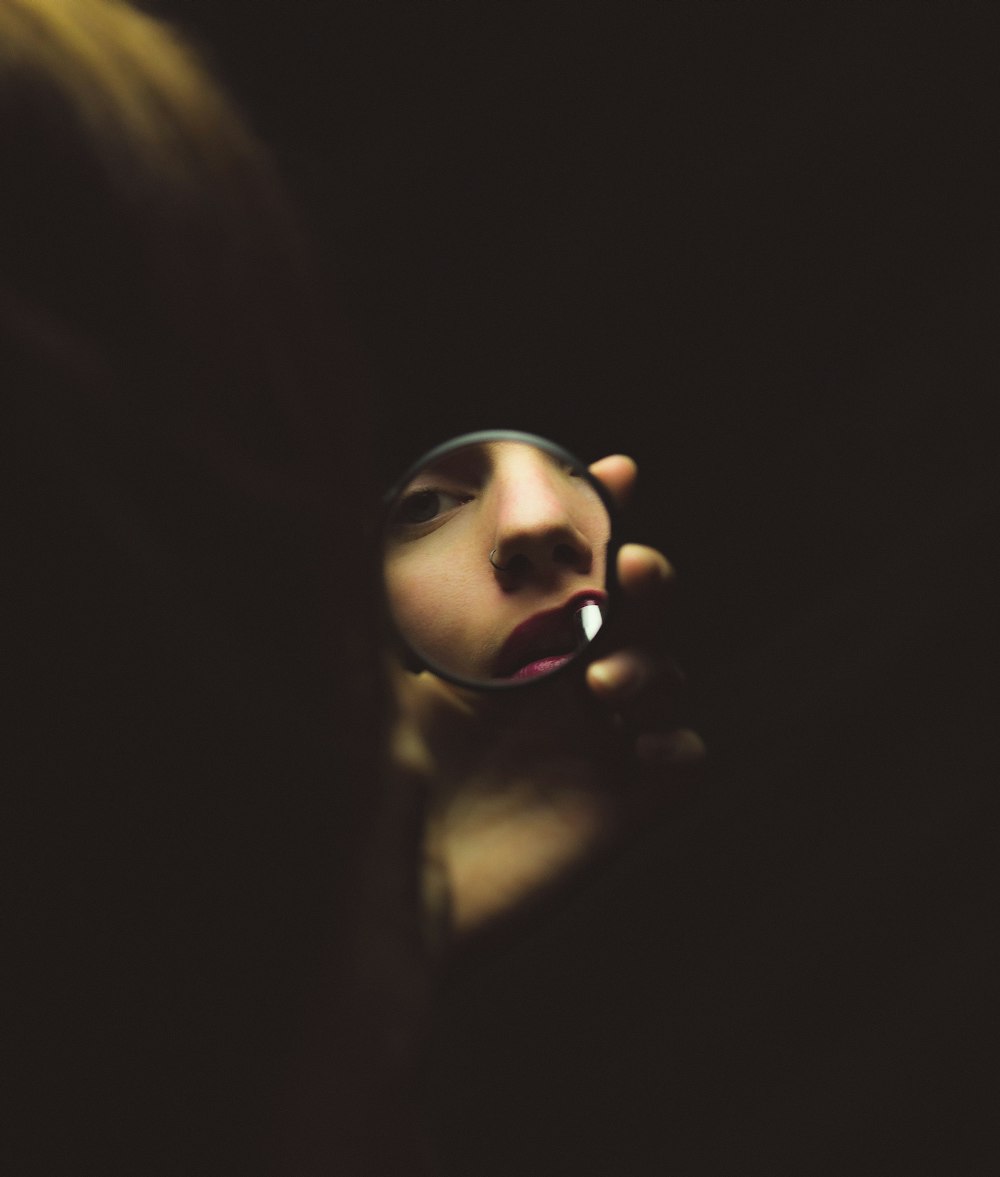 woman holding compact mirror