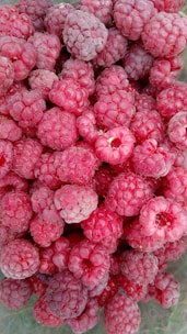 Close-up of vibrant frozen raspberries piled in a rustic bowl.