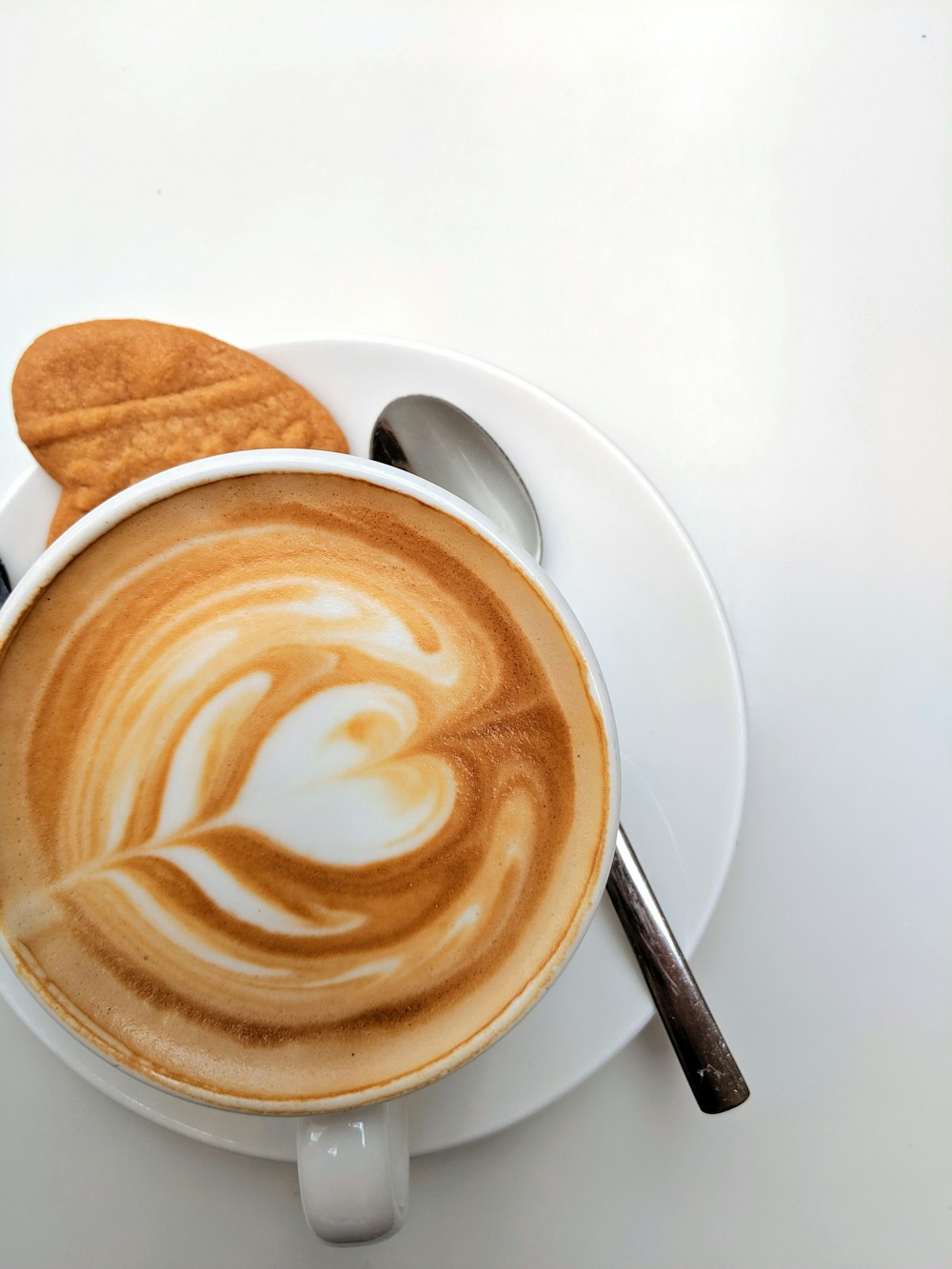 une tasse de café avec un biscuit dessus