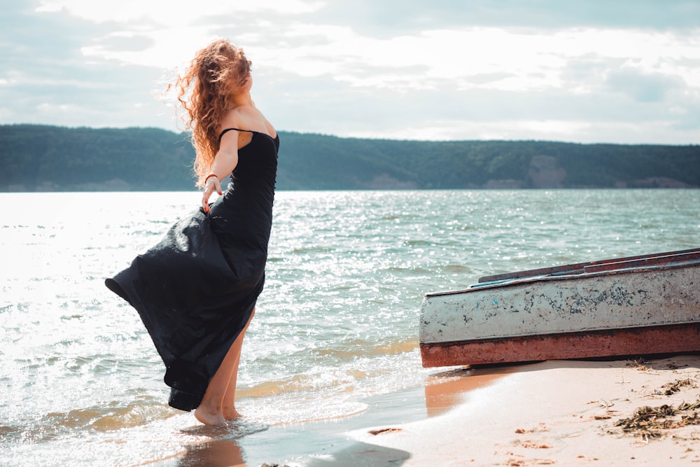 woman wearing black dress on seashore during daytime