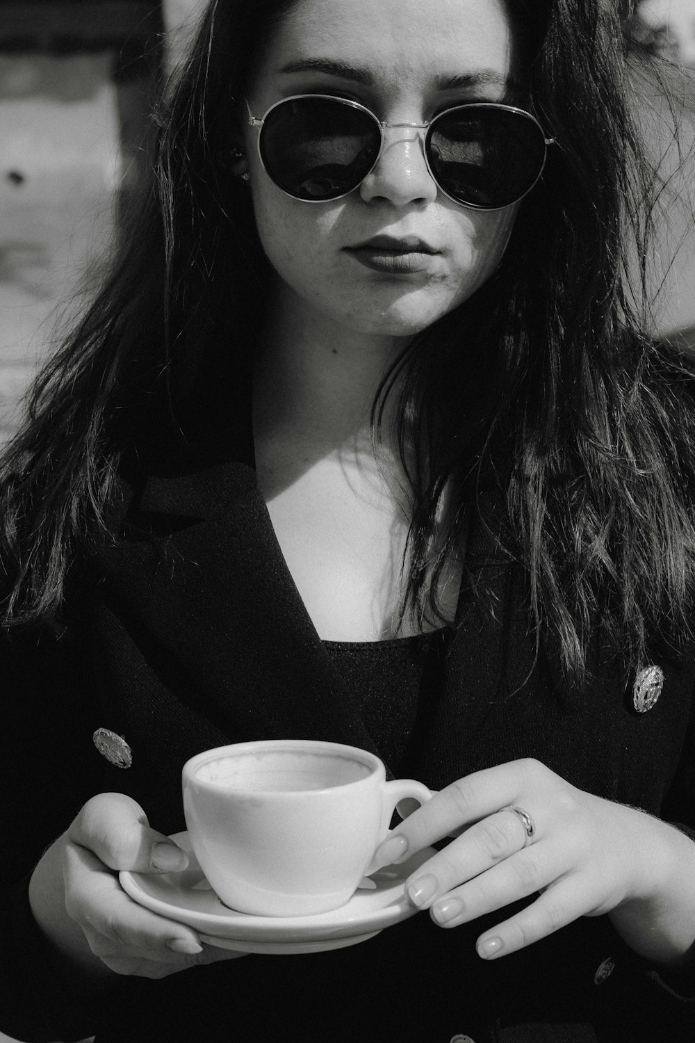 grayscale photography of woman holding teacup and saucer