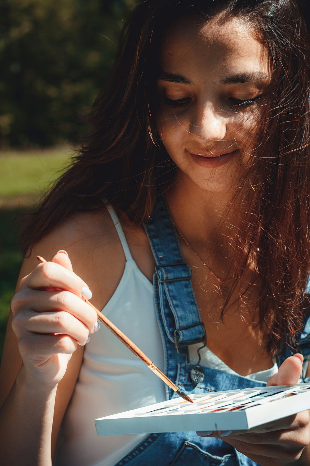 woman holding paint brush and paint palette