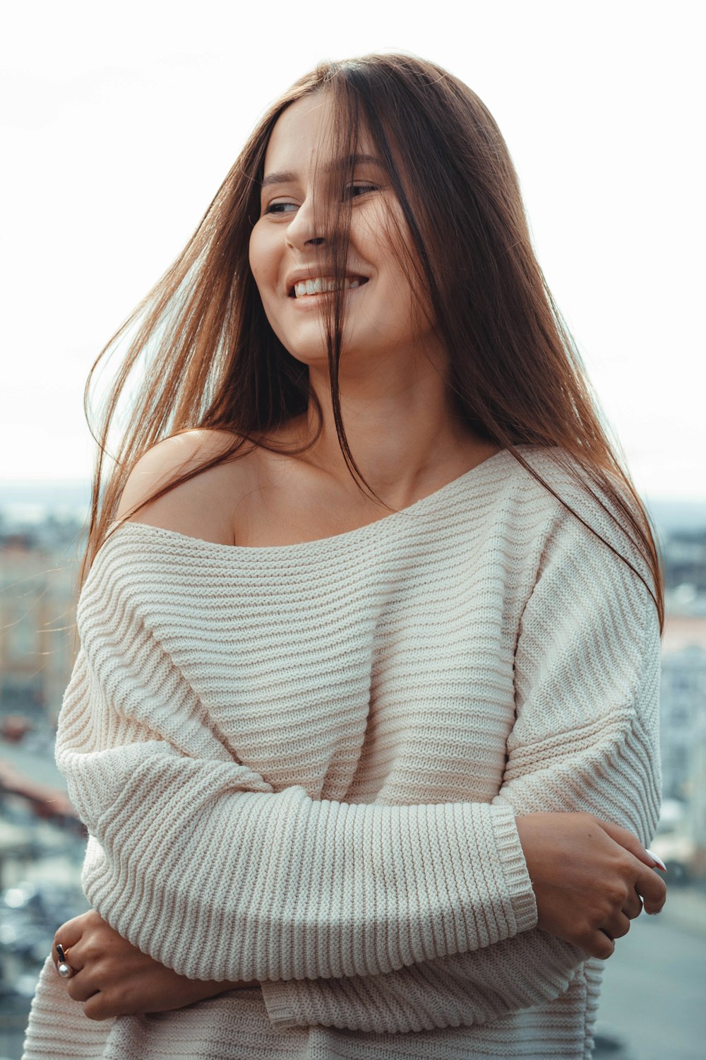 donna che indossa un maglione a righe bianche che ride mentre si alza in piedi