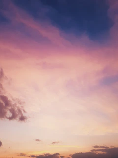 A serene pastel gradient sky blending soft purple, pink, and blue with delicate floating abstract shapes.
