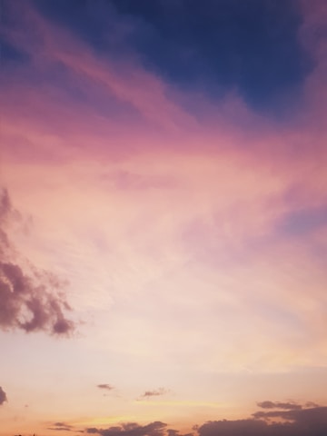 A surreal sky with floating clouds and soft pastel gradients inspired by Magritte.