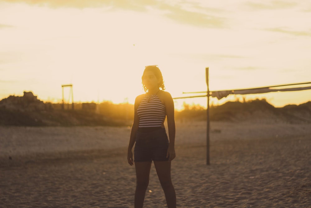 woman standing on sand during golden hour