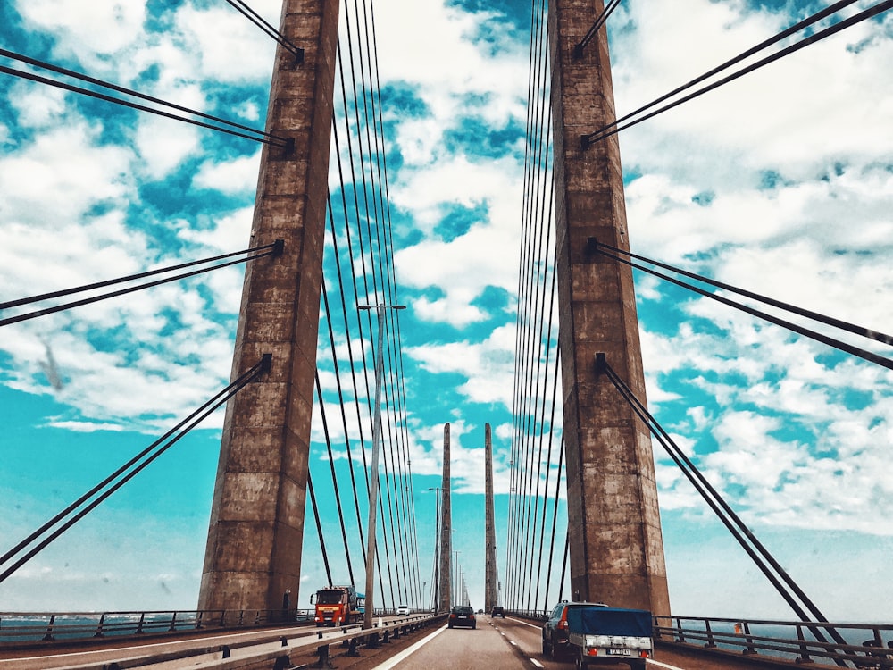 vehicles passing by a bridge during daytime