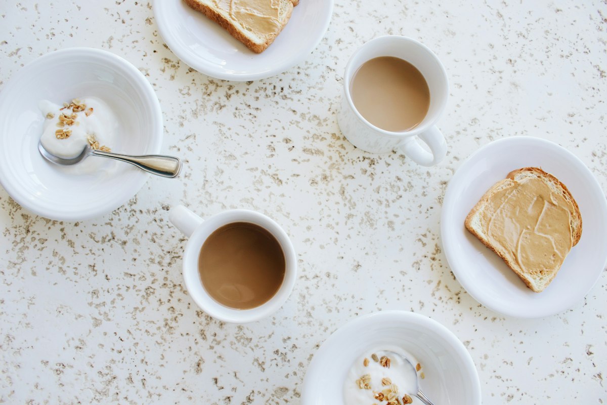 Desayuno de café con leche y tostadas en la mesa de un bar antes de empezar a caminar