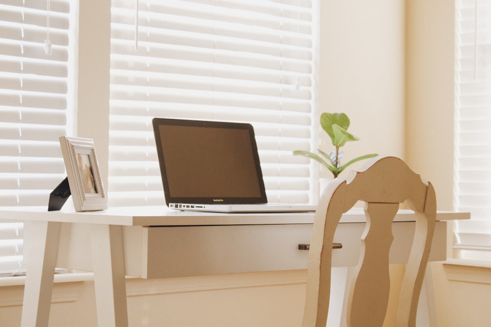 a laptop computer sitting on top of a wooden desk