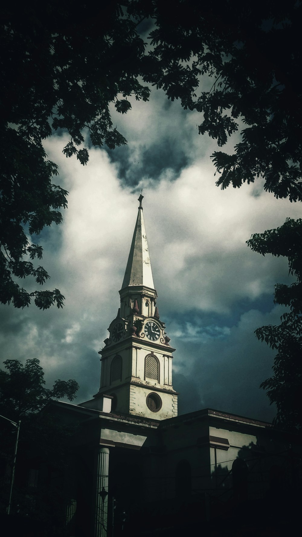 a church steeple with a cloudy sky in the background