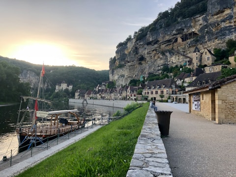 Overhead shot of a riverside village with colorful houses and boats along the shore.