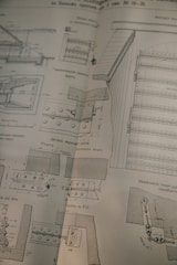 A detailed technical drawing on a slightly worn page, possibly from a book or manual, displaying various mechanical components and sectional views with measurements and annotations, drawn in black ink.