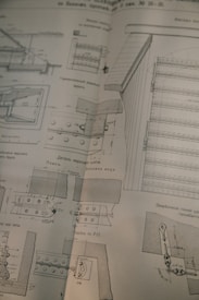 A detailed technical drawing on a slightly worn page, possibly from a book or manual, displaying various mechanical components and sectional views with measurements and annotations, drawn in black ink.