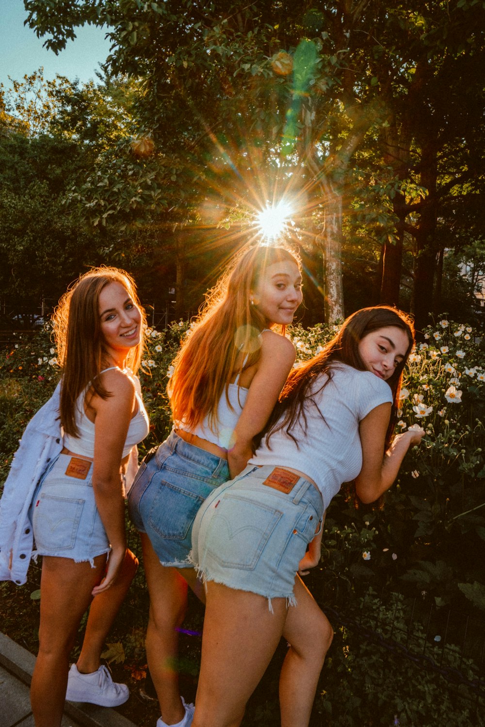 close-up photography of three woman standing near plant